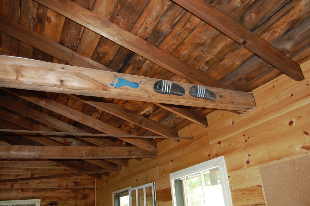 A newly built timber ceiling with exposed rafters and pine boarding above bright windows